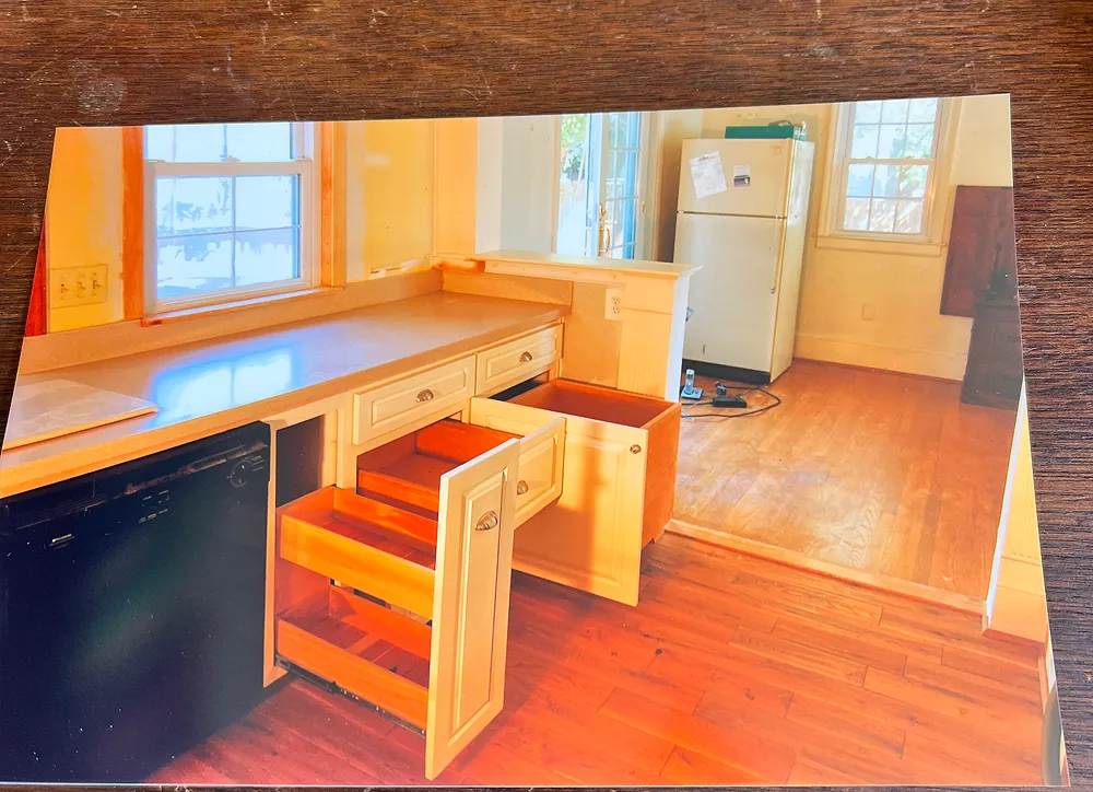 Kitchen with open drawers and refrigerator.
