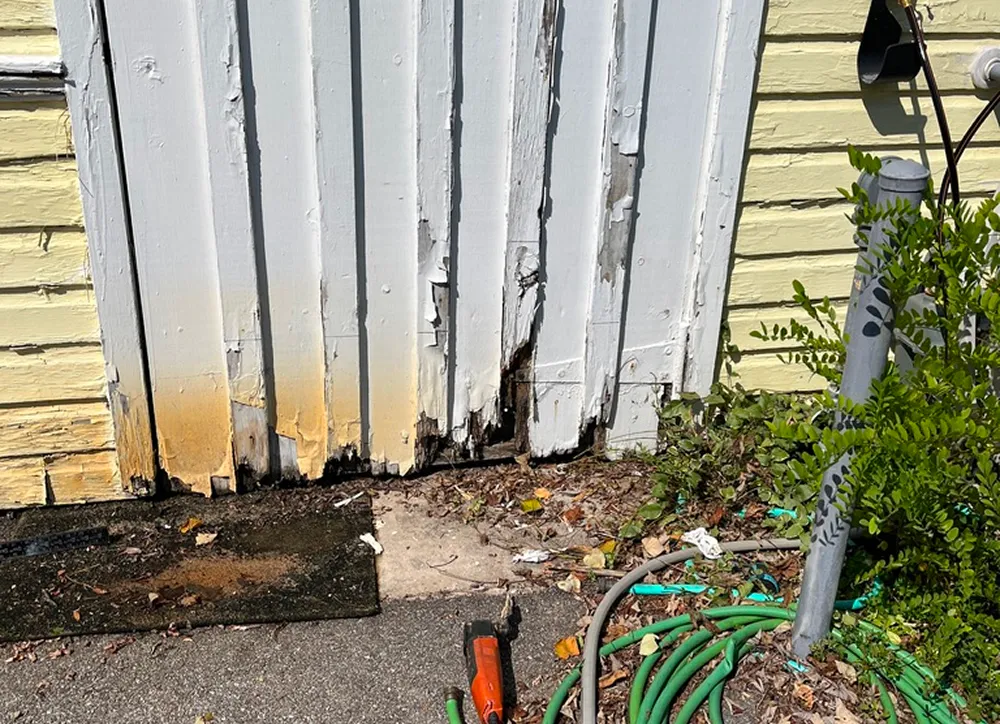 Damaged wooden door with peeling paint.