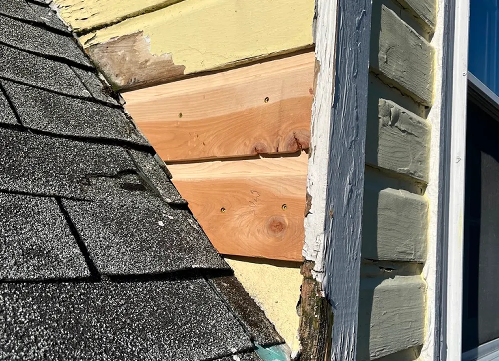 Roof and wall with wood repairs visible.