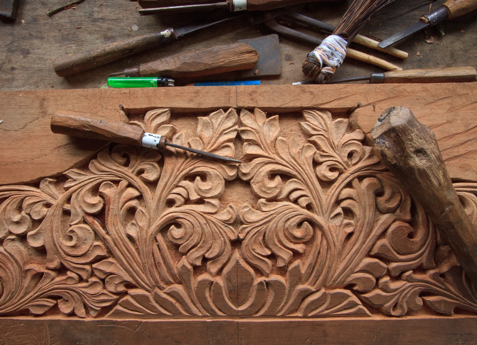Wood carving tools on intricate floral design