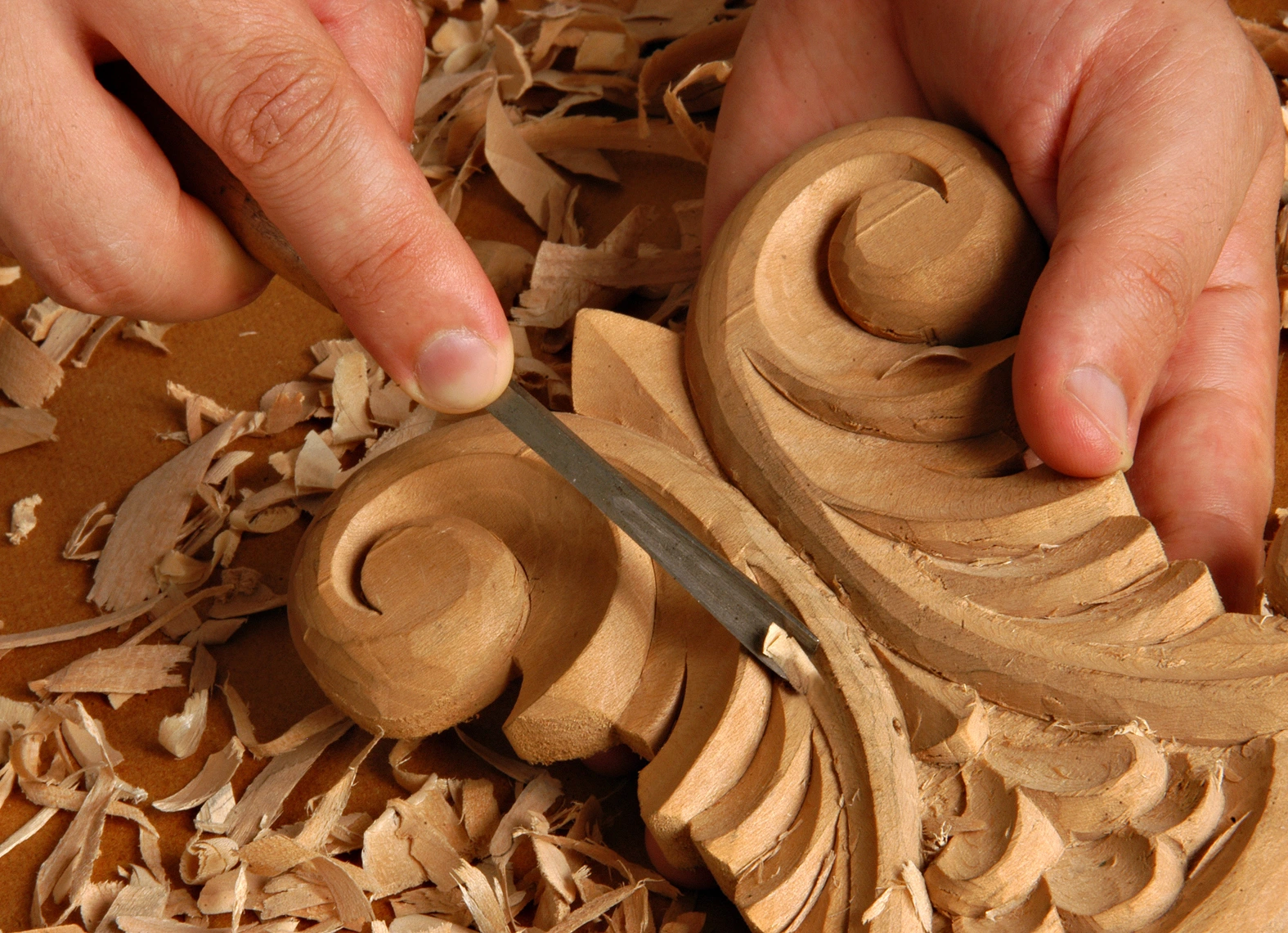 Artisan shaping detailed woodwork pattern