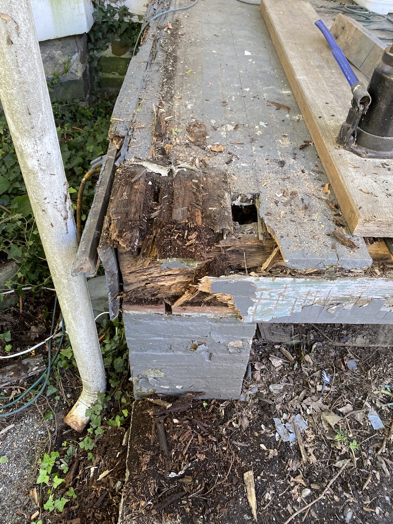 Rotting wooden deck with exposed damage.