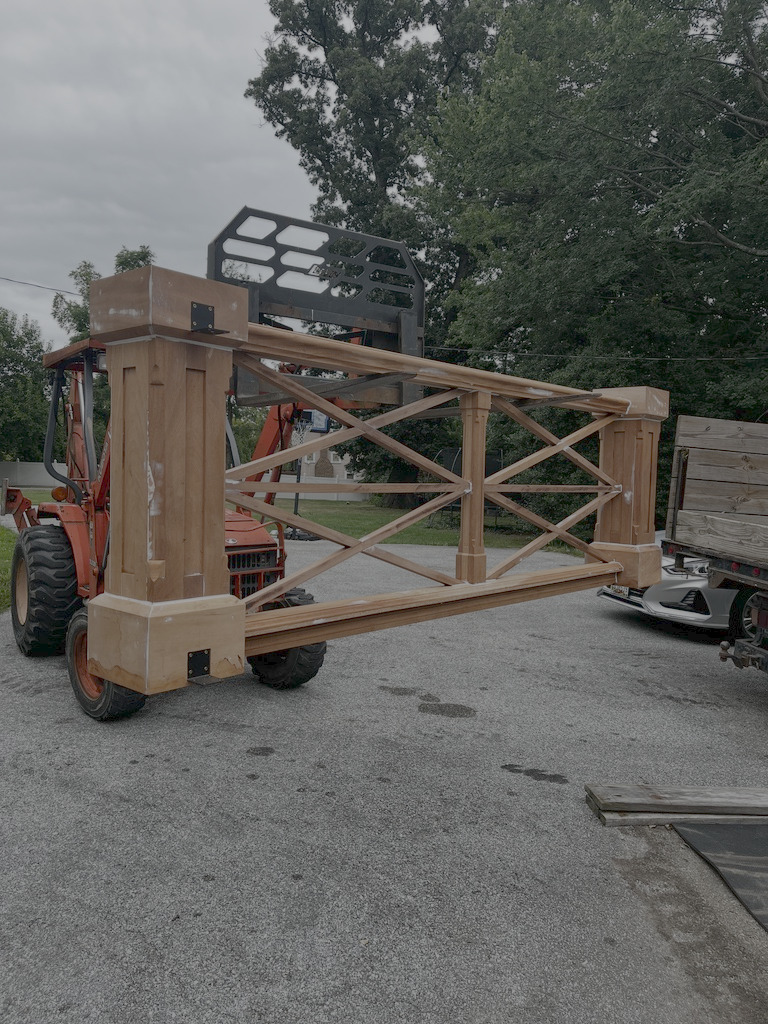Wooden structure lifted by a construction vehicle.